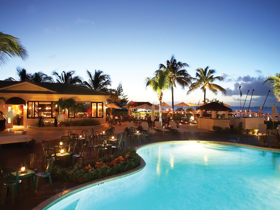 Hemingway's lit up at dusk behind the pool