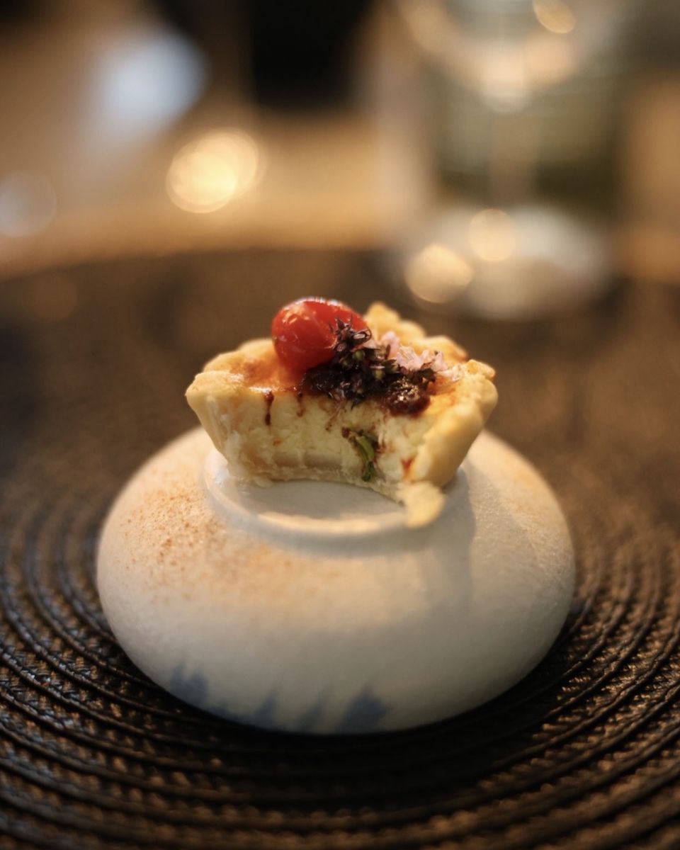 A cheese tart amuse-bouche topped with a cherry tomato at Ode to Gillian