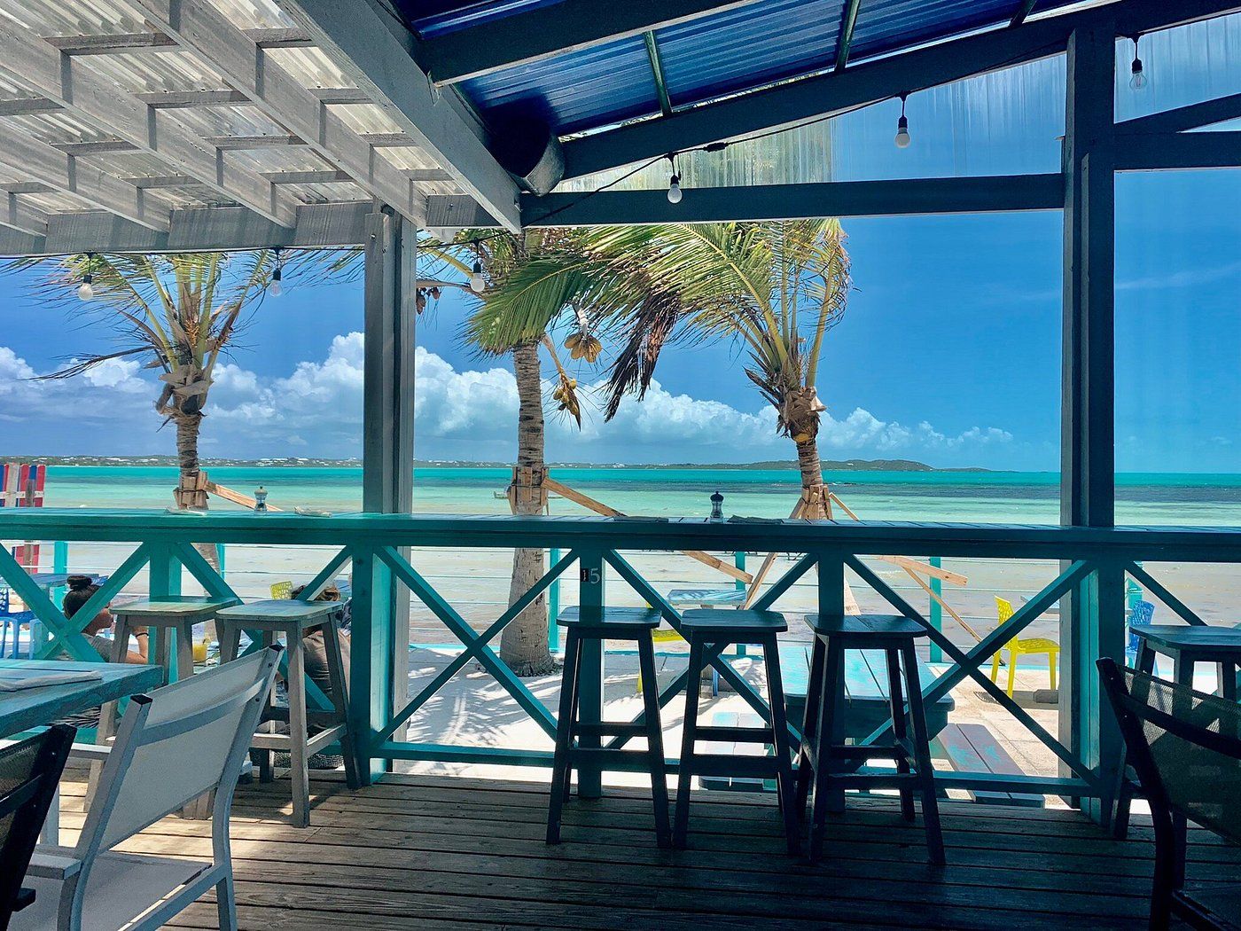 The covered deck at Omar's Beach Hut looking out over the turquoise water of Five Cays Beach
