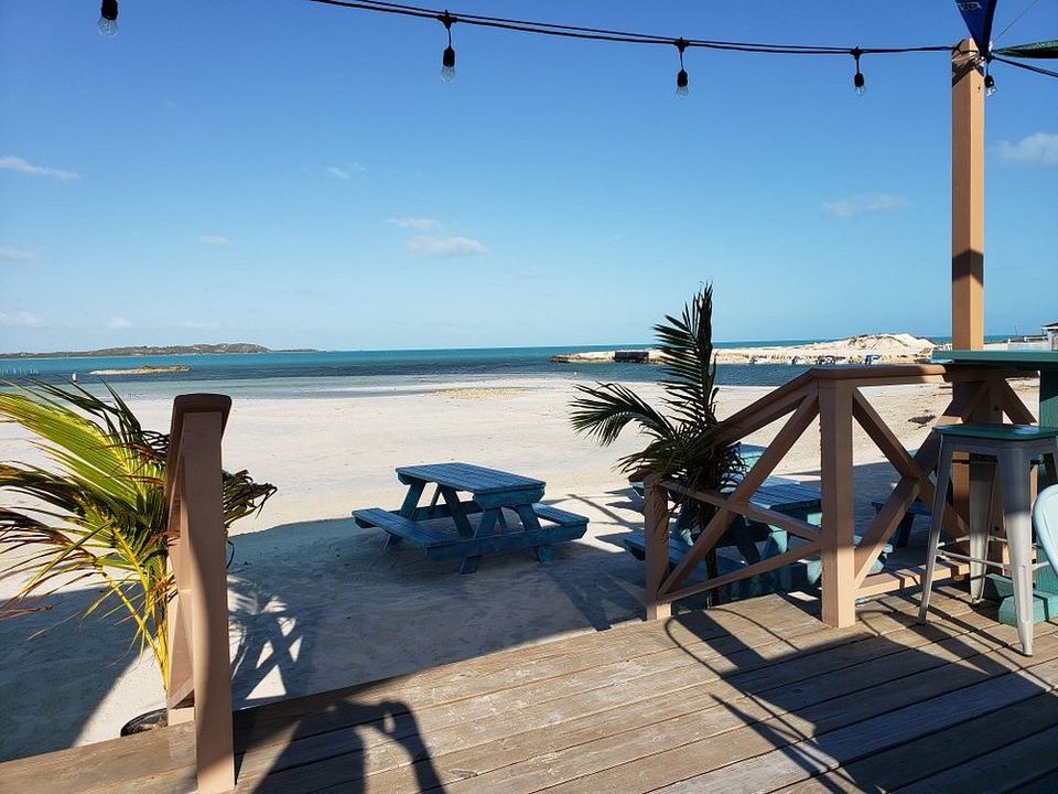 Steps from the deck at Omar's Beach Hut down to the sand and picnic tables on Five Cays Beach