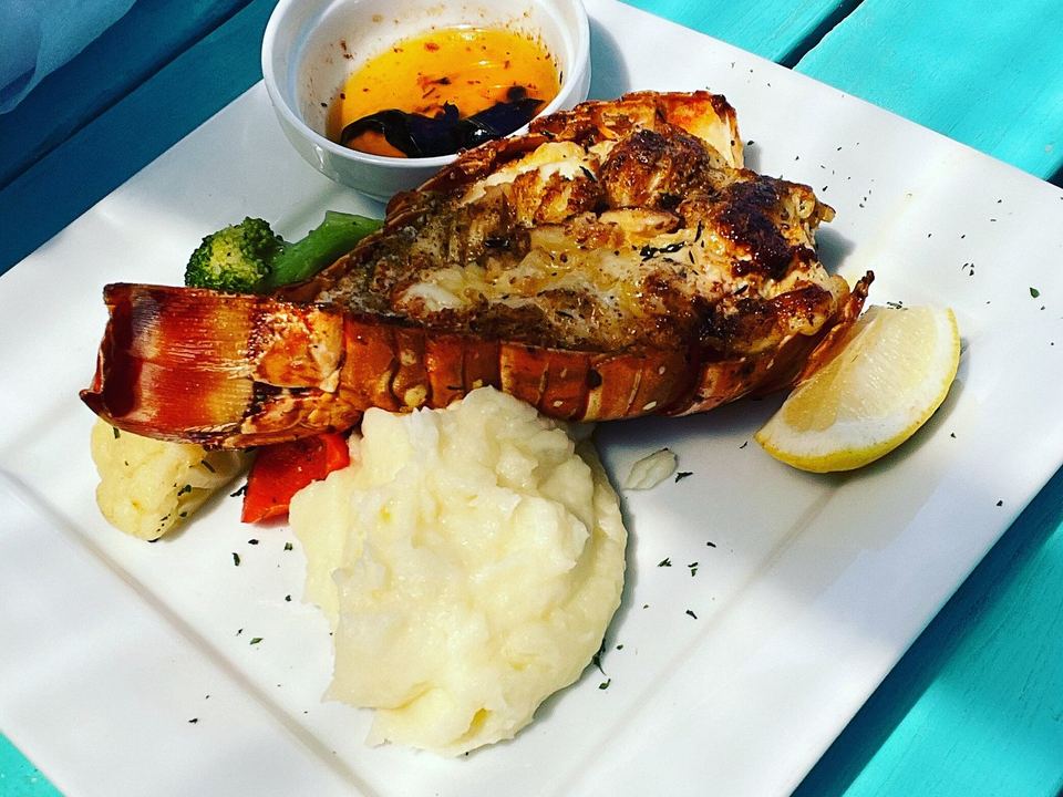 Grilled lobster tail at Omar's Beach Hut, with mashed potato, sautéed vegetables and garlic butter