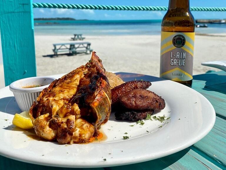 Jerk lobster tail with fried plantain and a Turks Head lager at Omar's Beach Hut