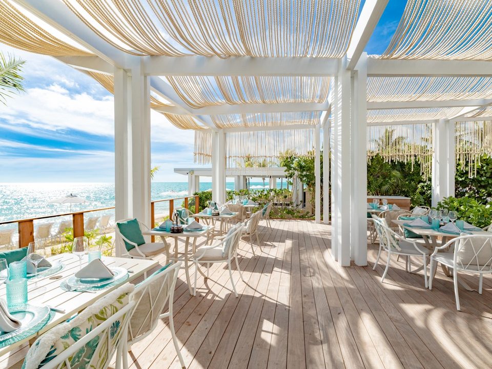 Tables on the Sea Grapes deck with the sea beyond