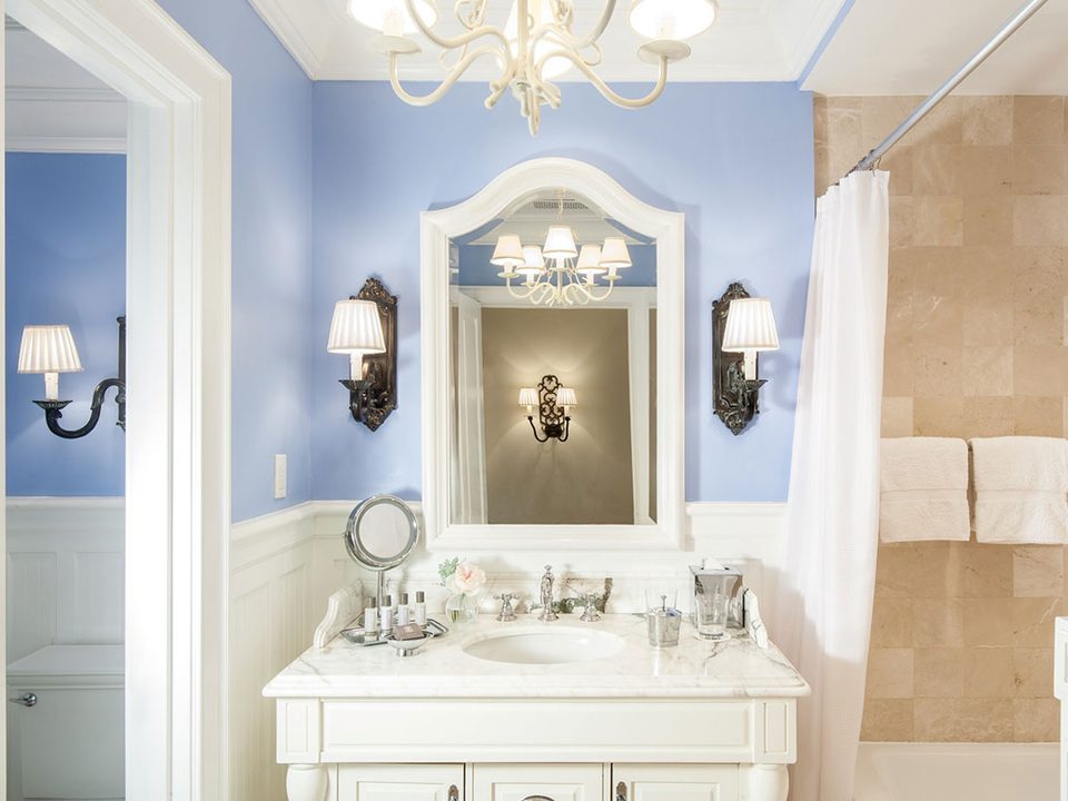 A suite bathroom with a chandelier and a white vanity
