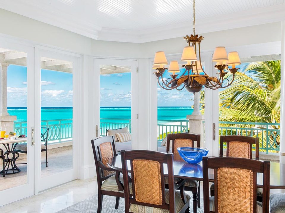 A suite dining table by windows facing the ocean