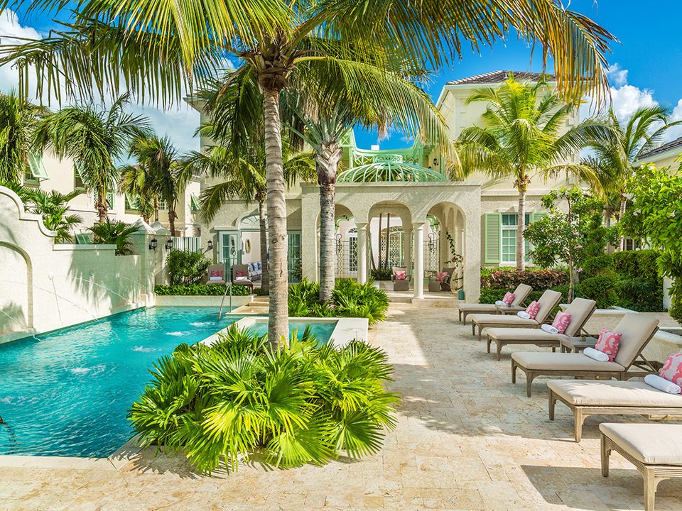 An Estate Villa's pool courtyard lined with loungers and palms