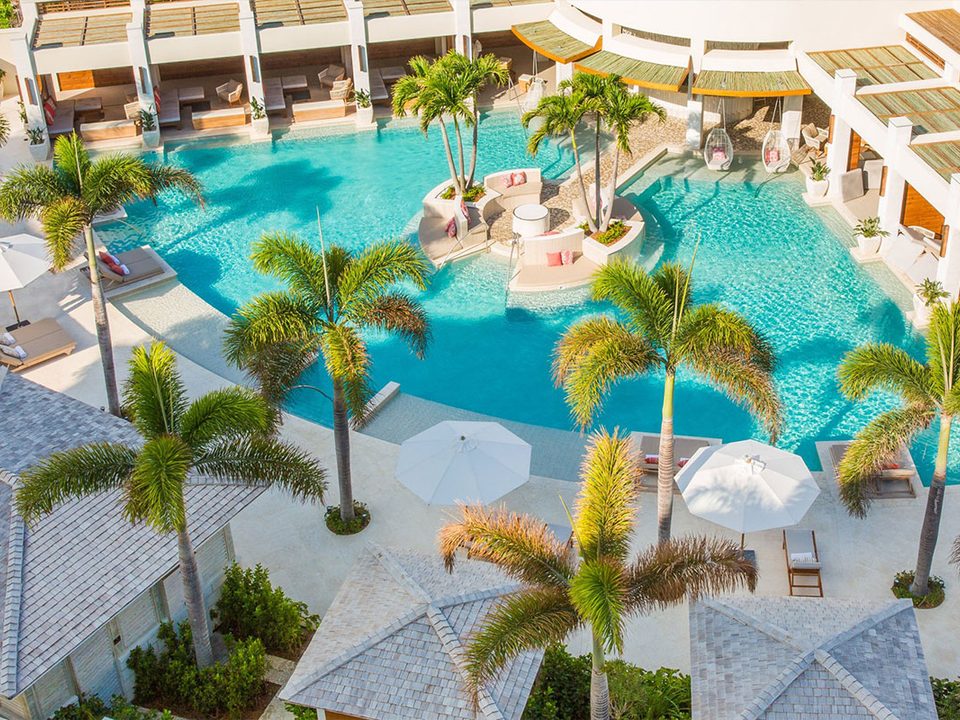 The lagoon pool from above, with palms, cabanas and umbrellas