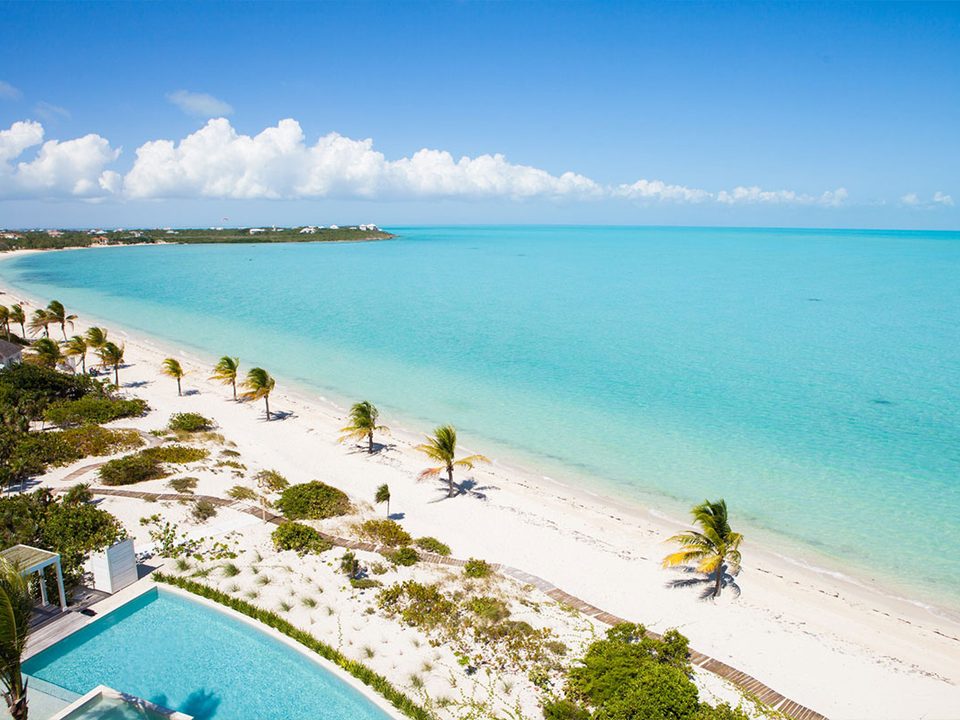 Long Bay Beach from above, with a villa pool in the dunes