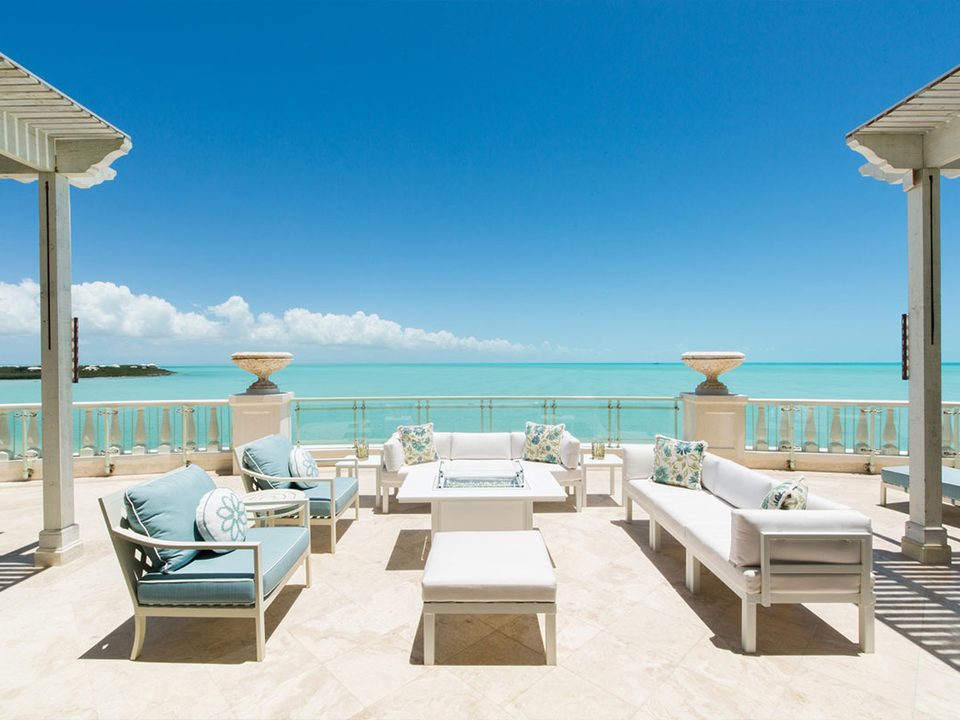 A penthouse terrace with sofas looking over Long Bay